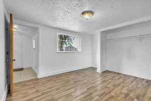 Bedroom #2 featuring a textured ceiling, a closet, and wood finished floors