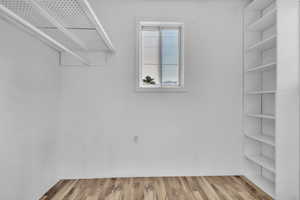 Spacious closet featuring light wood-style floors in primary bedroom