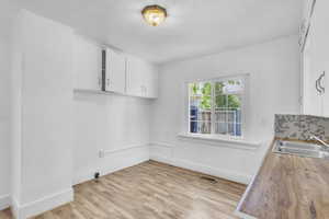 Kitchen/dining area with a sink and light wood-type flooring