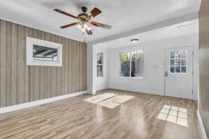 Entryway featuring wood walls, wood finished floors, and ceiling fan