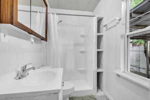 Bathroom featuring a shower with shower curtain and vanity