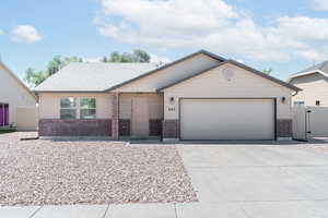 View of front of house with brick siding, concrete driveway, and a garage