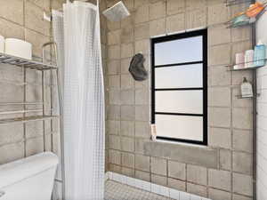 Bathroom with toilet and tiled shower
