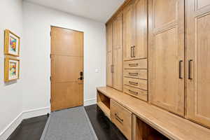 Mudroom with baseboards and concrete floors
