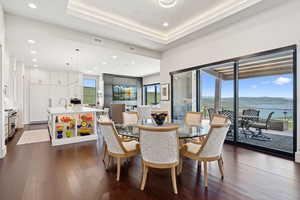 Dining room with dark wood-style flooring and recessed lighting