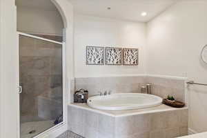 Bathroom featuring a garden tub, a shower stall, and recessed lighting
