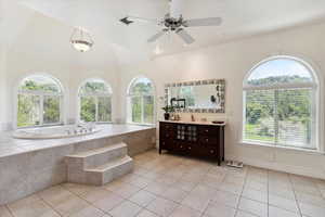 Bathroom featuring vanity, a garden tub, tile patterned flooring, vaulted ceiling, and a ceiling fan
