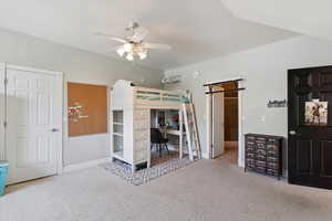 Carpeted bedroom with an office area and a ceiling fan