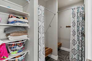 Full bath featuring a shower with curtain and baseboards