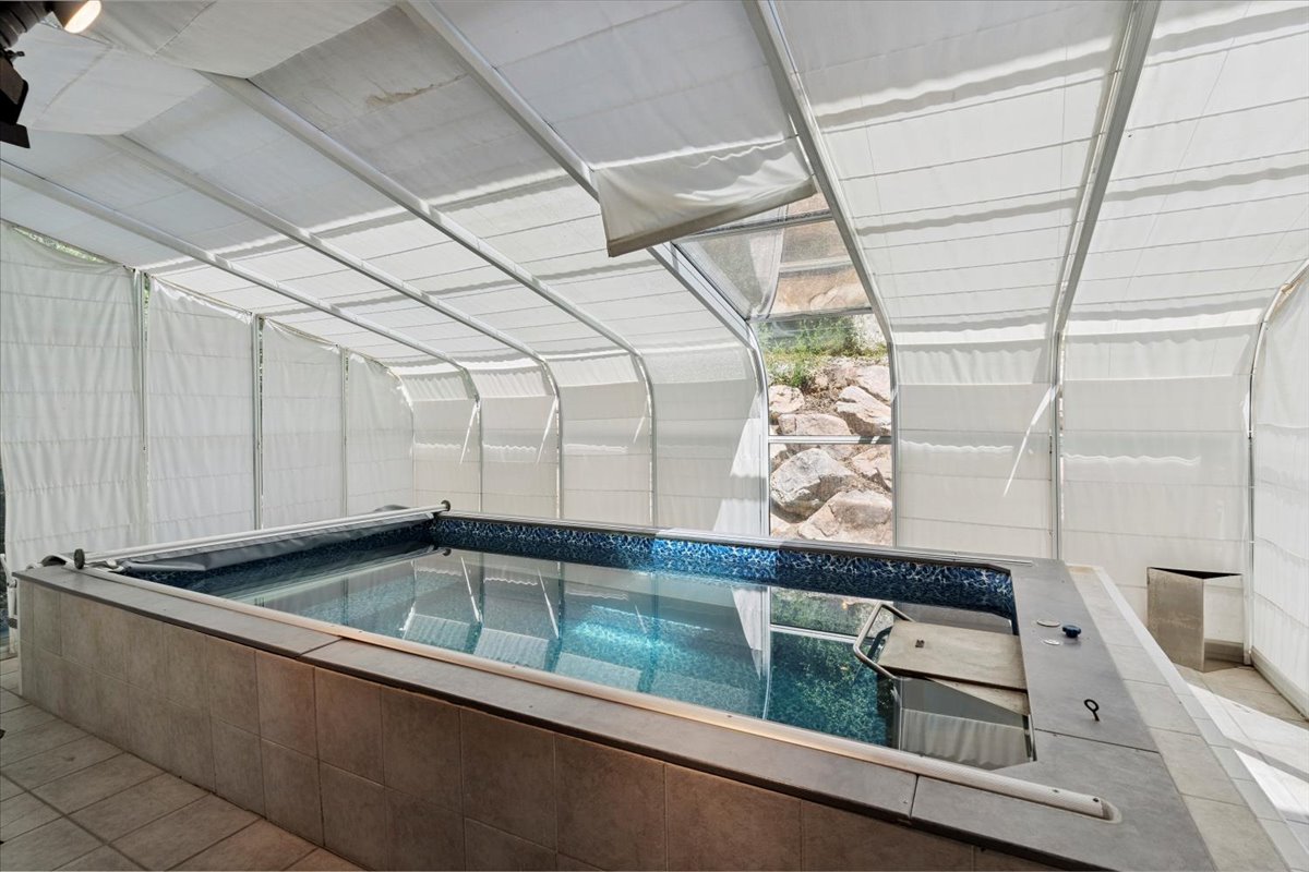 View of pool with a hot tub