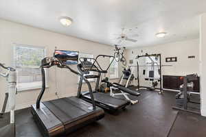 Workout area with a ceiling fan and a textured ceiling