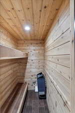 Sauna with wooden ceiling, wood walls, and wood finished floors
