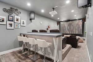 Home theater room with recessed lighting and wood finished floors