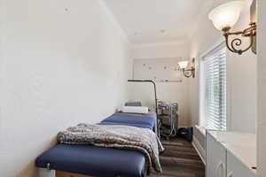 Bedroom featuring ornamental molding and dark wood-type flooring