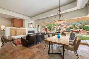 Dining area with stone tile floors, a raised ceiling, and recessed lighting
