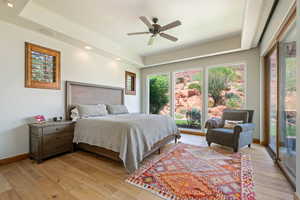 Bedroom with light wood-style flooring, access to outside, recessed lighting, a ceiling fan, and a raised ceiling
