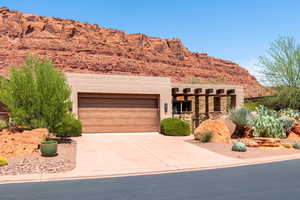 View of front facade featuring an attached garage, driveway, stucco siding, and a mountain view