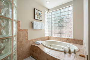 Full bath with healthy amount of natural light and a jetted tub
