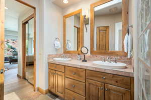 Ensuite bathroom with double vanity and wood finished floors