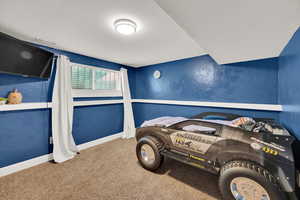 Bedroom featuring carpet and baseboards