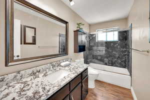 Bathroom featuring vanity, and bath / shower combo with glass door