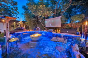 View of outdoor fire pit, an outdoor kitchen, and a patio