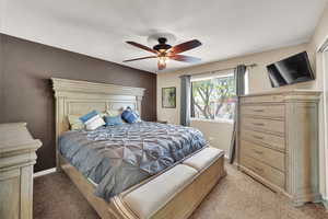 Bedroom featuring light colored carpet and a ceiling fan
