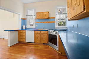 Kitchen featuring dishwasher, stainless steel range with gas cooktop, and light wood-style flooring