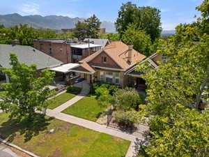 View of front facade featuring a chimney, a mountain view, brick siding, and a shingled roof