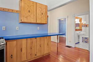 Kitchen featuring stainless steel range, hardwood / wood-style floors, and a kitchen bar