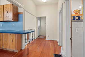 Corridor with light wood-type flooring and baseboards