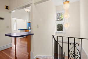 Stairway with wood finished floors and baseboards