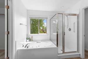 Full bathroom with a shower stall and a jetted tub