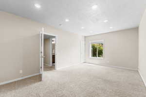 Empty room with recessed lighting and light carpet