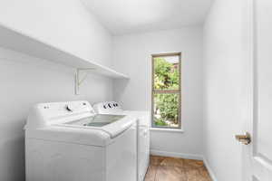 Laundry room featuring washing machine and dryer and light tile patterned floors