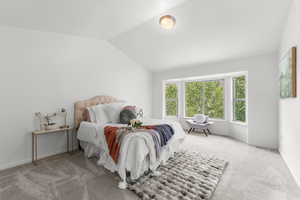 Carpeted bedroom with lofted ceiling and baseboards