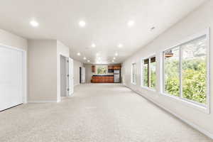 Unfurnished living room with recessed lighting and light colored carpet