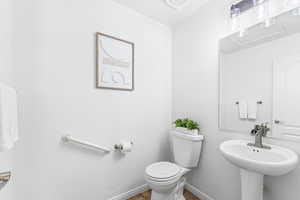 Half bathroom with toilet and tile patterned flooring