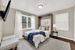 Bedroom featuring wood finished floors and baseboards