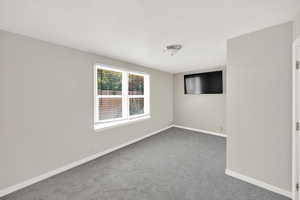 Unfurnished room with baseboards and carpet