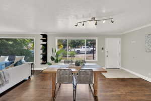 Dining space featuring wood finished floors, ornamental molding, and a textured ceiling