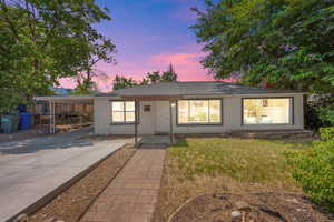 Ranch-style house with concrete driveway, a carport, and a chimney