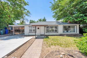 Single story home featuring driveway, a chimney, and an attached carport