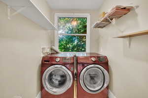 Washroom featuring independent washer and dryer and baseboards