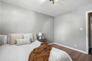 Bedroom featuring baseboards and wood finished floors