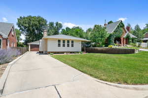 View of front of property featuring a garage, an outdoor structure, and a chimney