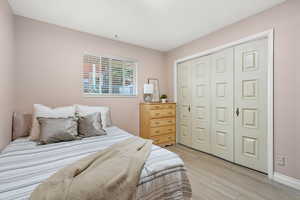 Bedroom featuring light wood-type flooring and a closet