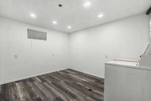 Laundry room featuring washer and dryer, dark wood-type flooring, and recessed lighting