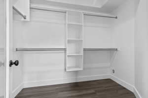 Walk in closet featuring dark wood-style floors for primary bedroom