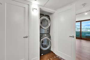 Washroom with stacked washer and clothes dryer and rail lighting